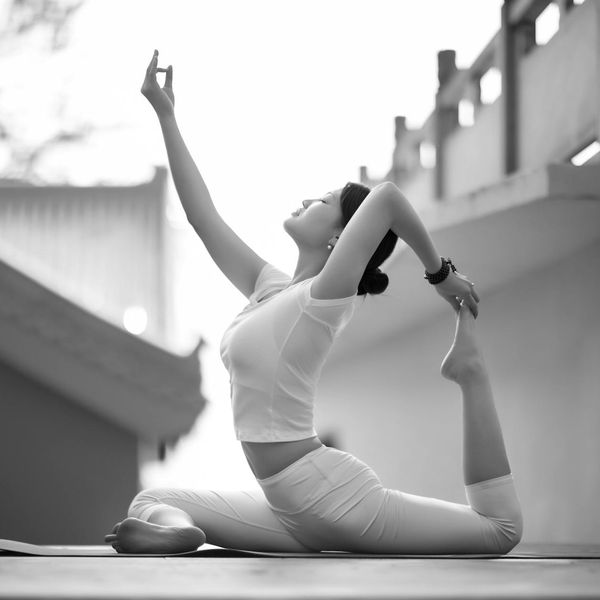 Woman in a peaceful yoga pose, embodying harmony and balance in a calm setting.
